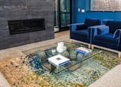 Thumbnail 16 of 36 - A living room with a fireplace and blue chairs.